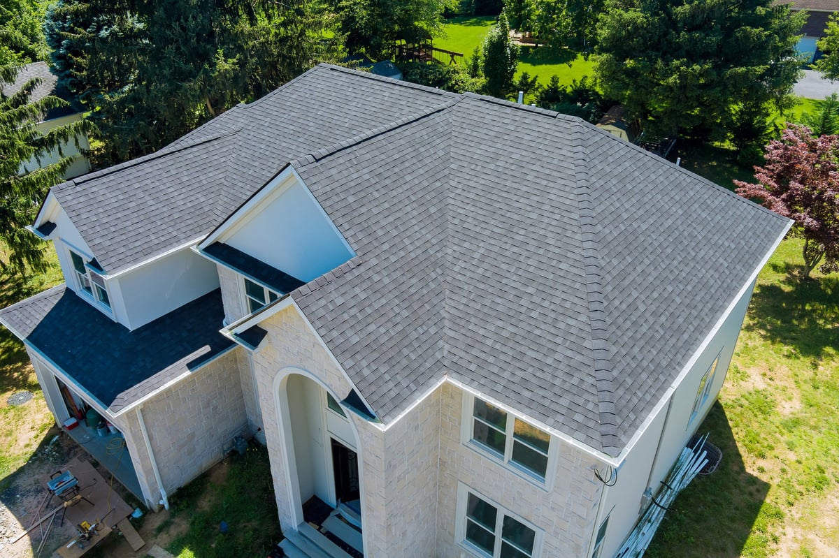 Aerial view of a residential roofing project with new shingles being installed