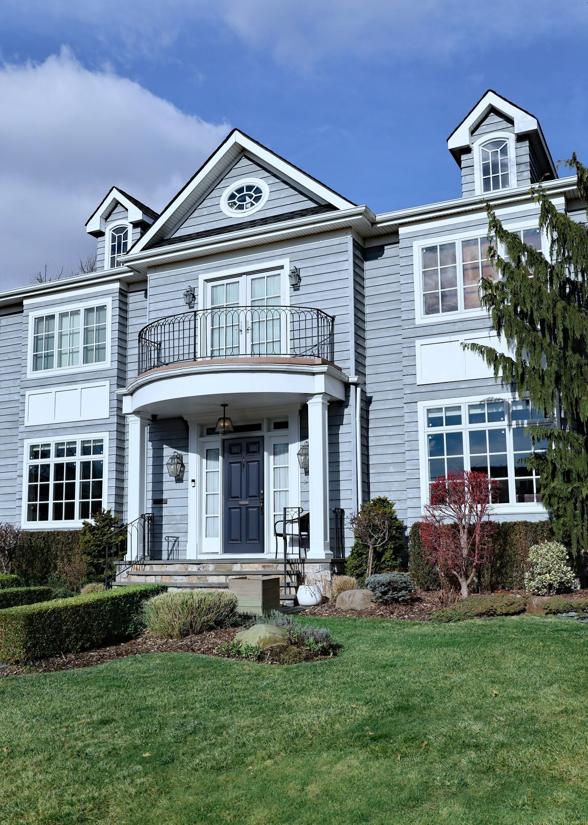 Modern suburban house with gray siding and dormer windows